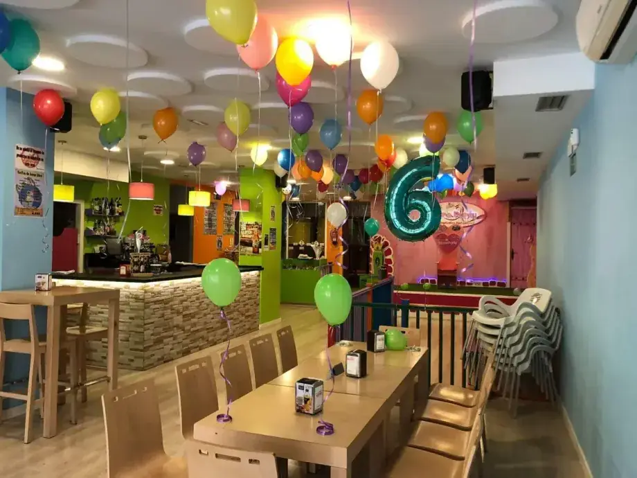 Zona de celebración de Héroes y Princesas con mesas y globos